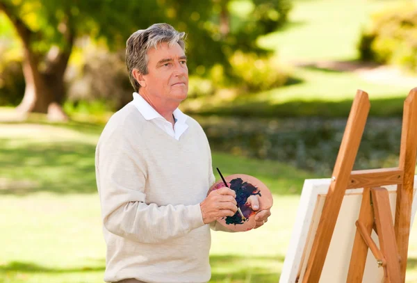 Starší muž, malování v parku — Stock fotografie