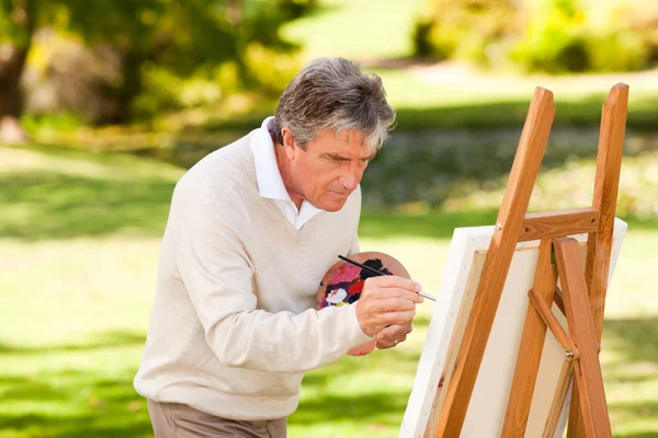 Äldre man målning i parken — Stockfoto