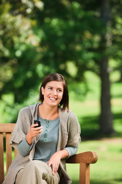 Femme téléphone sur le banc — Photo