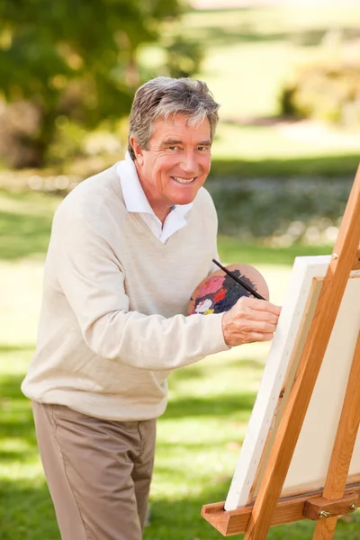 Homem idoso pintando no parque — Fotografia de Stock