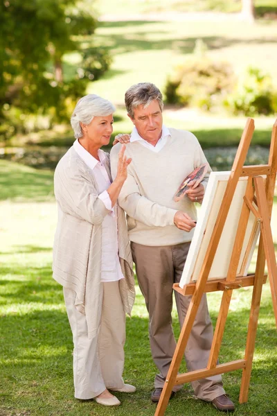 Retired couple painting in the park — Stock Photo, Image