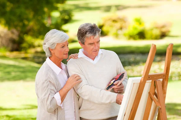 Retired couple painting in the park — Stock Photo, Image