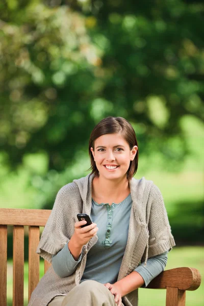 Woman phoning on the bench — Stock Photo, Image