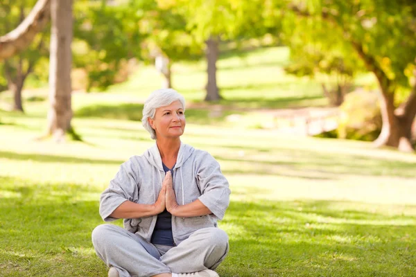 Mulher madura praticando ioga no parque — Fotografia de Stock