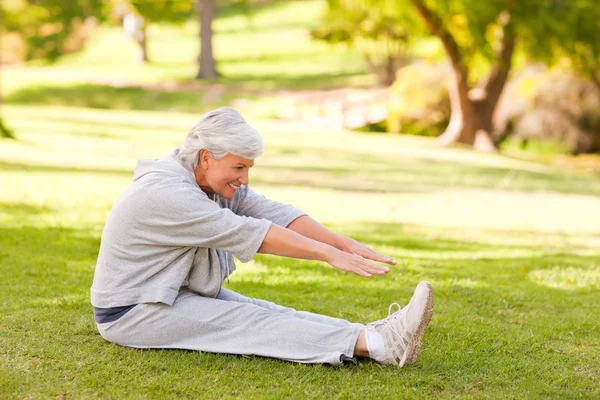 Mujer jubilada haciendo sus estiramientos en el parque — Foto de Stock
