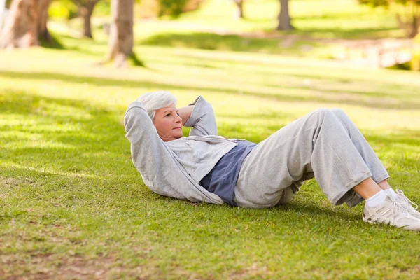 Retired woman doing her stretches in the park — Stock Photo, Image