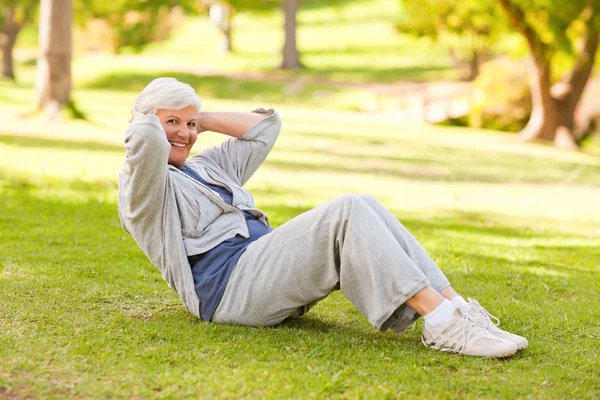 Mulher aposentada fazendo seus alongamentos no parque — Fotografia de Stock