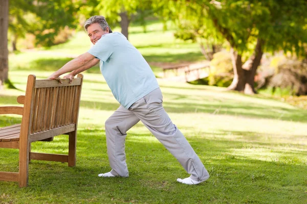 Retired man doing his stretches in the park — Stock Photo, Image