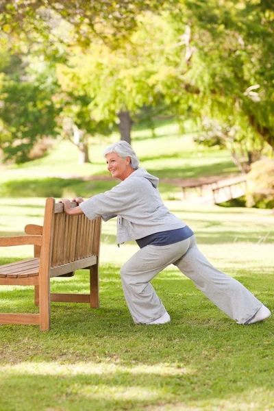 Donna anziana che fa i suoi tratti nel parco — Foto Stock