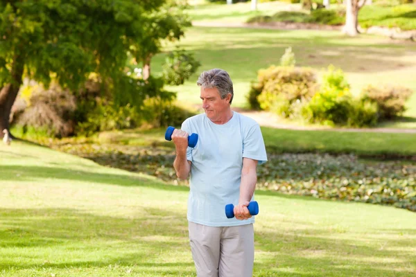 Osoby w podeszłym wieku człowiek robi jego ćwiczenia w parku — Zdjęcie stockowe