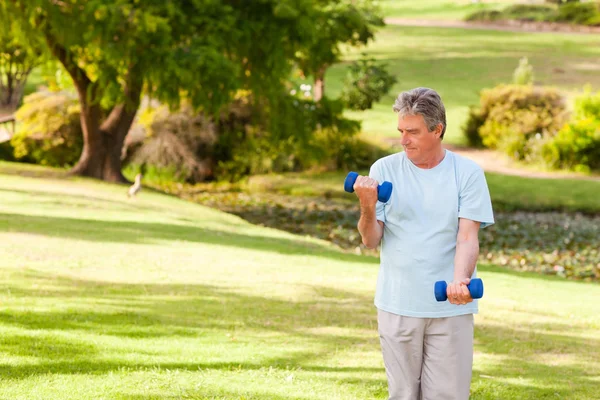 Пожилой человек делает упражнения в парке — стоковое фото