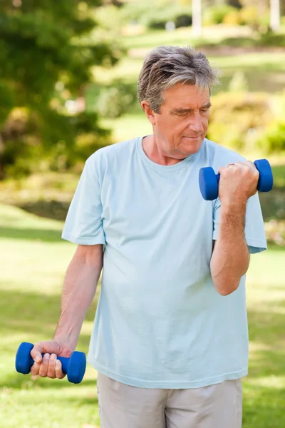 Elderly man doing his exercises in the park — Stock Photo, Image