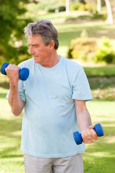 Пожилой человек делает упражнения в парке — стоковое фото