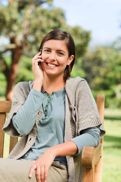 Young woman phoning on the bench — Stock Photo, Image