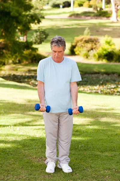 Зрелый мужчина делает упражнения в парке — стоковое фото