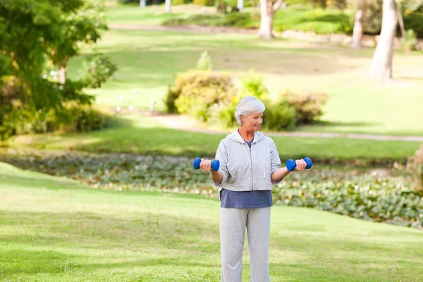 Mature woman doing her exercises in the park — Stock Photo, Image