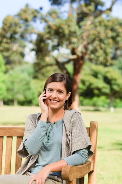 Jeune femme téléphonant sur le banc — Photo