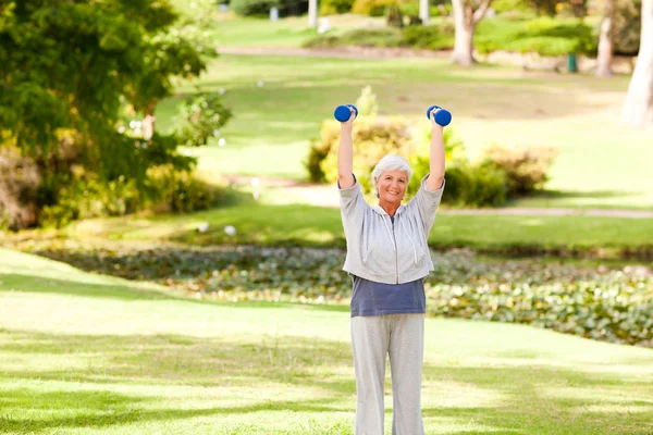 Starsza kobieta robi jej ćwiczenia w parku — Zdjęcie stockowe