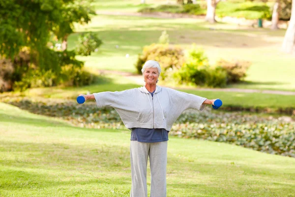 Ώριμη γυναίκα που κάνει τις ασκήσεις στο πάρκο — Φωτογραφία Αρχείου