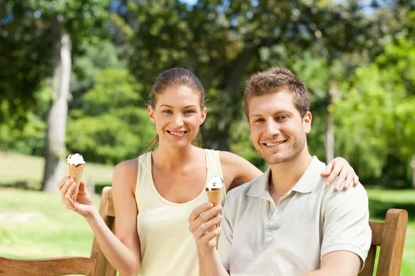 Couple eating an ice cream in the park — Stock Photo, Image