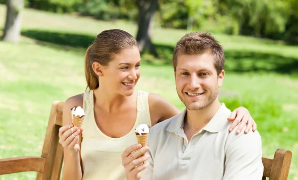 Casal comendo um sorvete no parque — Fotografia de Stock