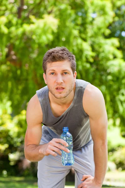 Sportieve man drinkwater in het park — Stockfoto