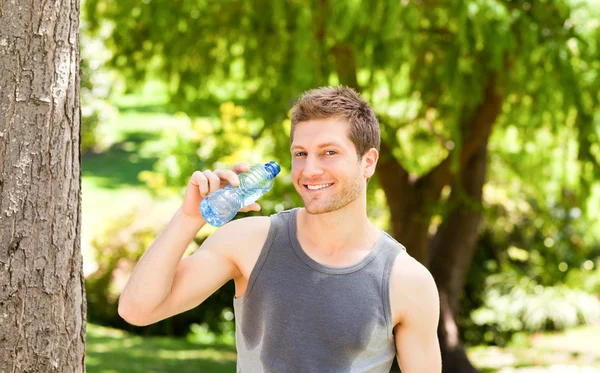 公園でスポーティな男飲料水 — ストック写真