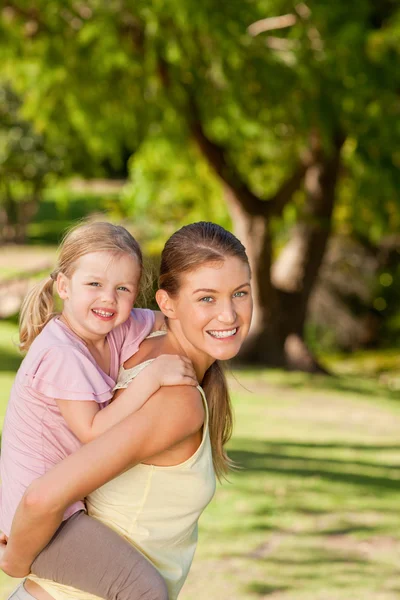 Vacker mor ge dottern en piggyback — Stockfoto