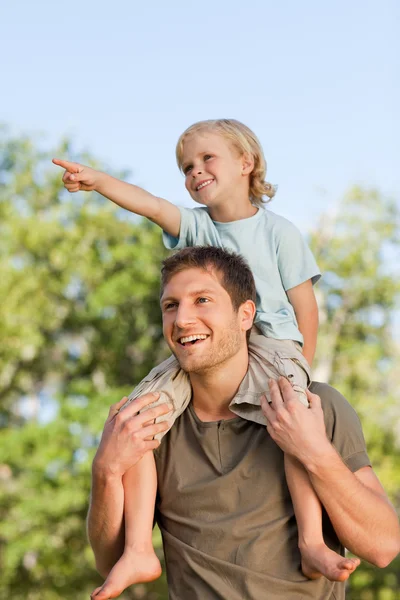 Šťastný otec dává synovi na zádech — Stock fotografie