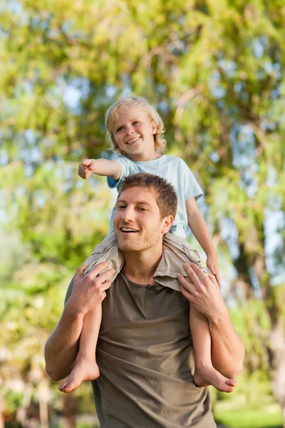 Pai feliz dando ao filho um piggyback — Fotografia de Stock