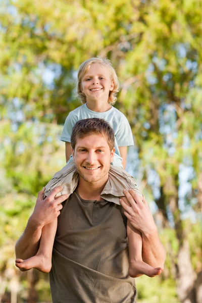 Šťastný otec dává synovi na zádech — Stock fotografie