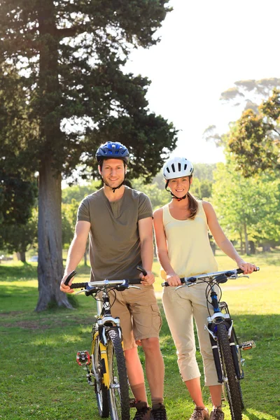 与他们在公园里的自行车，情侣 — 图库照片