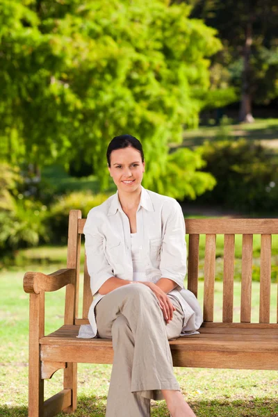Bruneta žena na lavičce — Stock fotografie