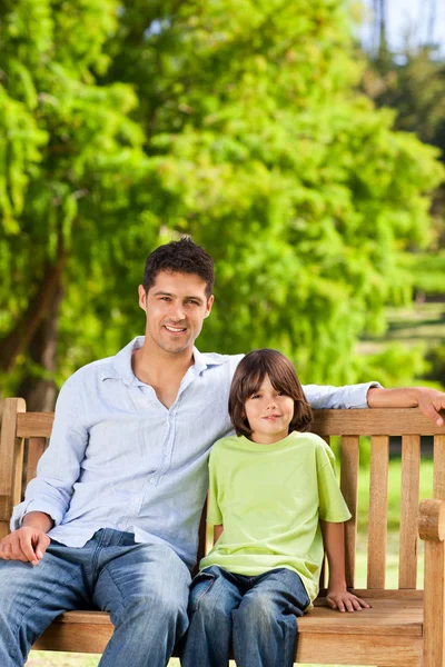 父亲和他的儿子坐在板凳上 — 图库照片