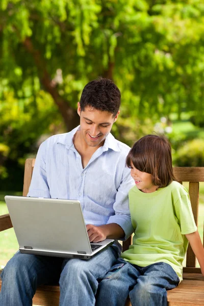 Father with his son looking at their laptop — Stock Photo, Image