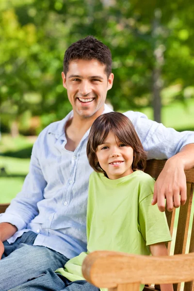 Son med sin far på bänken — Stockfoto