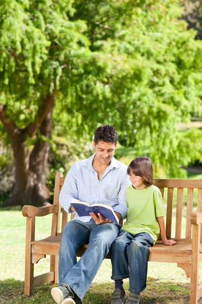 Padre con suo figlio che legge un libro — Foto Stock