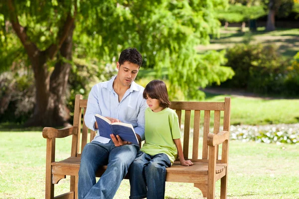 Pai com seu filho lendo um livro — Fotografia de Stock