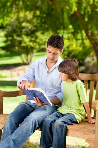 Vader met zijn zoon lezen van een boek — Stockfoto