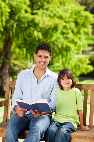 Son med sin far som läser en bok — Stockfoto