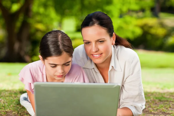 Mor og datter ser på laptopen deres. – stockfoto