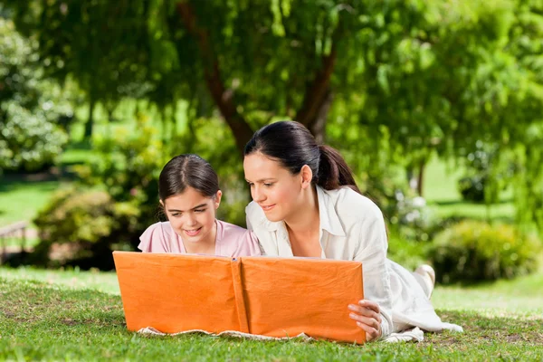Mother and her daughter looking at their album photo — Stock Photo, Image
