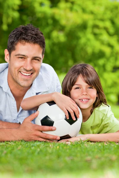 Vader en zoon met hun bal in het park — Stockfoto
