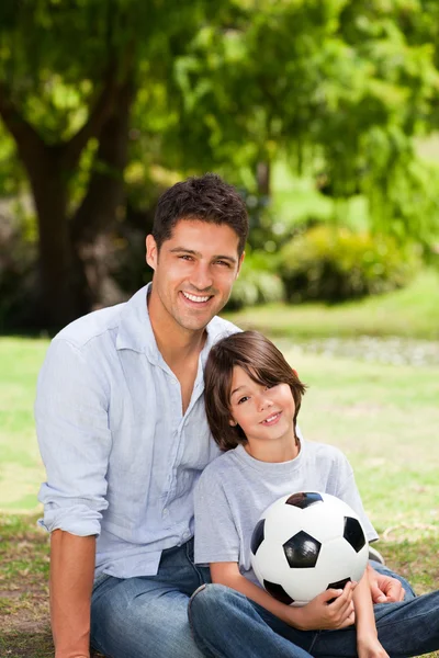 Vader en zoon met hun bal in het park — Stockfoto