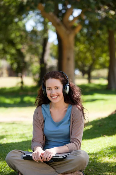 Mujer escuchando algo de música en el jardín Imagen de stock
