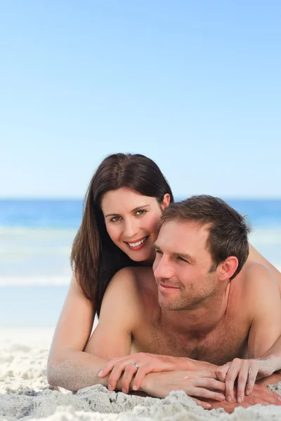Couple lying down on the beach Royalty Free Stock Images