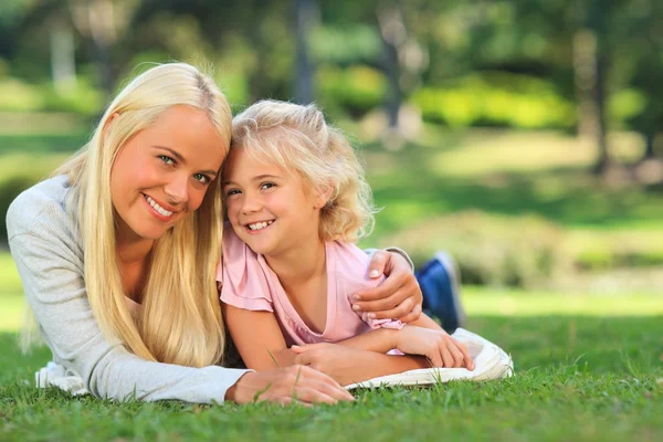Mother with her daughter lying down in the park Royalty Free Stock Images