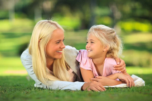 Mutter mit Tochter im Park liegend Stockbild