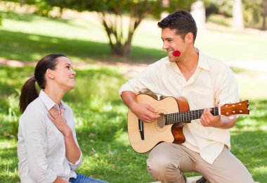 Man playing guitar for his girlfriend clipart