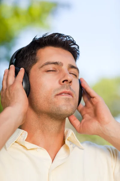남자는 공원에서 음악을 듣고 — 스톡 사진